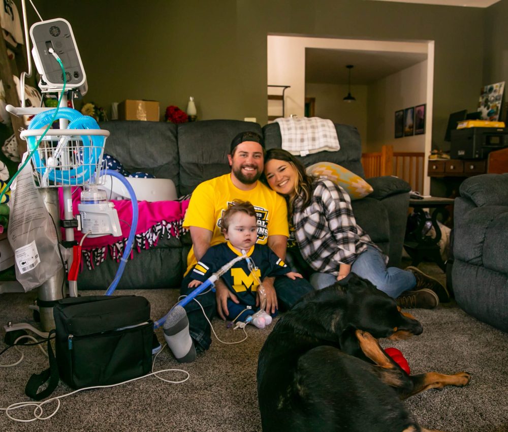 A mom, dad and son at home with their dog